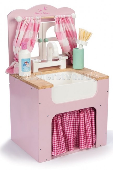 Деревянная игрушка LeToyVan Игровой набор Кухонная мойкаИгровой набор Кухонная мойка Деревянная игрушка LeToyVan Игровой набор Кухонная мойкаИгровой набор Кухонная мойкаLeToyVan Игровой набор Кухонная мойка. Игровой набор Кухонная мойка с аксессуарами Le Toy Van для детей от 3 лет. В 2014 году английская компании Le Toy Van расширила линейку детских игрушек на тему кухня, посуда, еда и выпустила новый, очень интересный набор с аксессуарами. Теперь наш интернет-магазни Кукладом может предложить своим маленьким покупателям не только разнообразные игровые наборы с игрушечной посудой, едой и бытовой техникой, но также возможность помыть посуду после званного ужина или обеда. Кухонная мойка - это неотъемлемый предмет мебели любой кухни. И чем он ярче и привлекательнее, тем интереснее играть. Тумба под мойку выполнена в розовых тонах. Верхняя часть сделана в виде двухстворчатого окна. На карнизе висят очаровательные занавески из ткани. Сама мойка комбинированная: столешница под цвет натурального дерева и белоснежная раковина из натурального камня. Классический смеситель с изогнутым носиком и двумя кранами. Под мойкой организовано место для хранения посуды и кухонной утвари, которое закрывается в стиле кантри текстильной шторкой на сборке и особенно привлекает классическим рисунком в мелкую красную клеточку. Кстати, дизайнеры постарались даже в детской игрушке учесть все детали и мелочи. Шторки внизу по рисунку и цвету перекликаются с занавесками у окна. А в комплект с мойкой предусмотрительно добавили флакон с моющим средством и зеленый стаканчик с щеткой.Вручите вашему ребенку игровой набор Кухонная мойка с аксессуарами Le Toy Van, возможно, это именно то, о чем он так долго мечтал. Игровой набор Кухонная мойка: мойка и тумба для хранения окно с занавесками на карнизе столешница и белоснежная раковина классический смеситель с двумя кранами занавески из ткани пузырек с моющим средством и стакан со щеткой размер игрушки 34.4x53.4x29.5 см. красивая подарочная упаковка.<br>